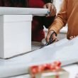 photo of a person s hands cutting wrapping paper