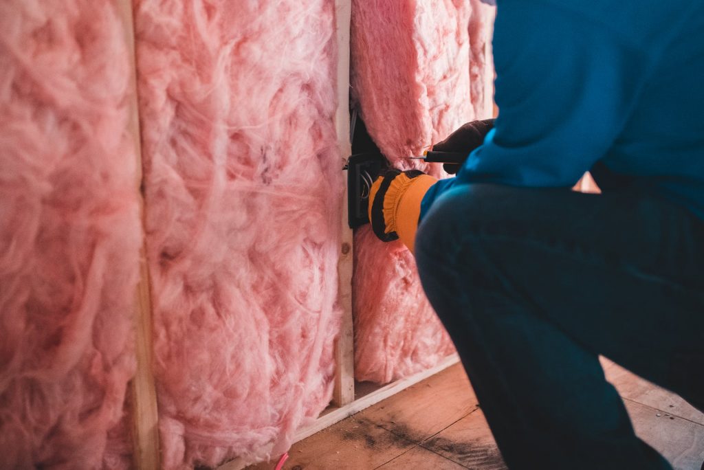 unrecognizable worker insulating with stone wool