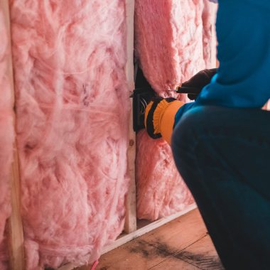 unrecognizable worker insulating with stone wool
